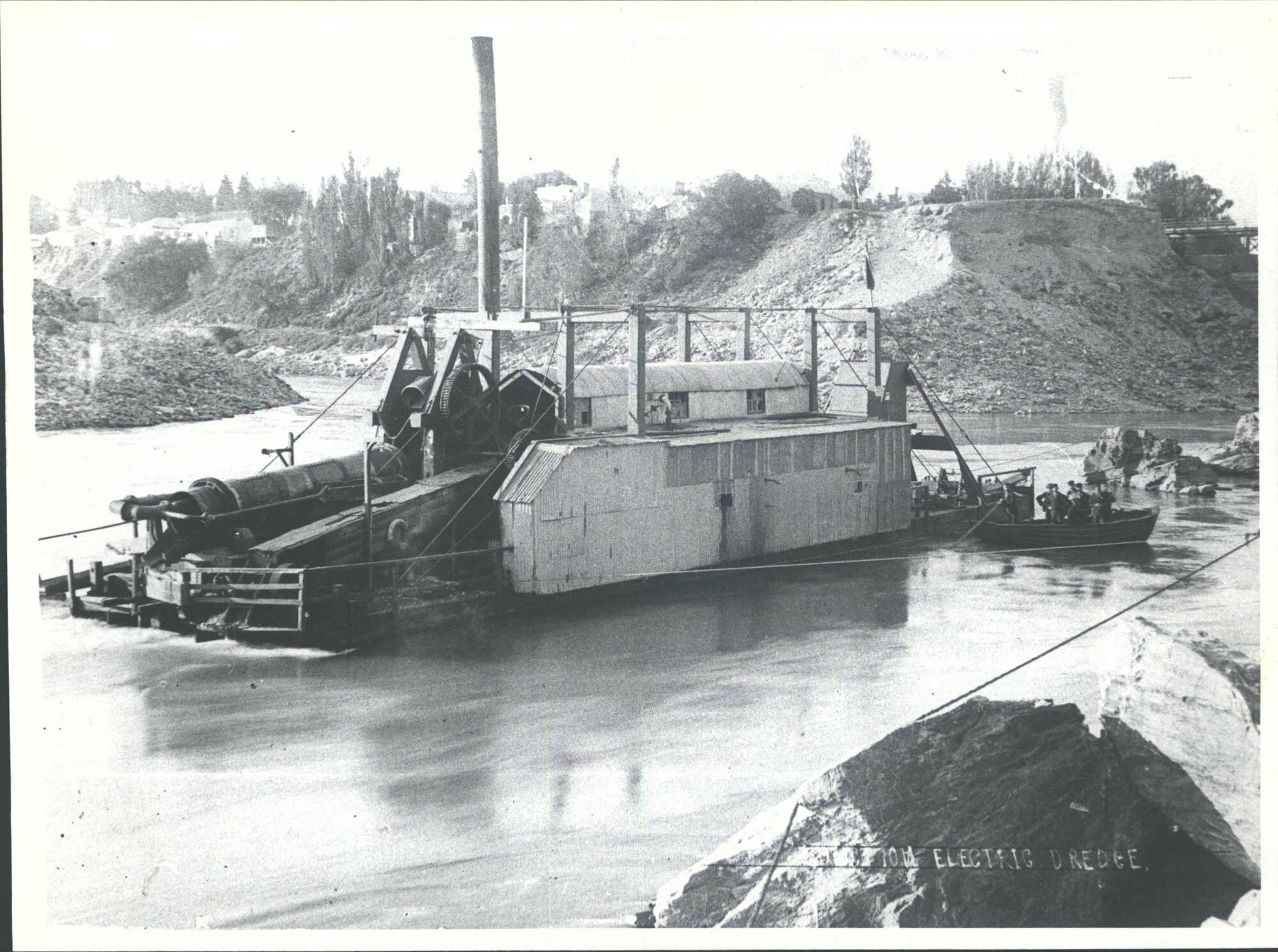 Junction Electric Dredge on the Clutha River just below junction of the Kawarau and Clutha Rivers. The bridge shown on the right