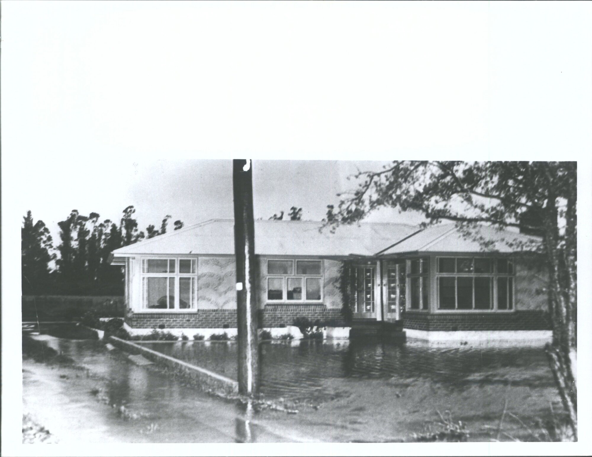 "a newly built brick house on the Mosgiel - Outram road Junction, isolated by flood waters".
