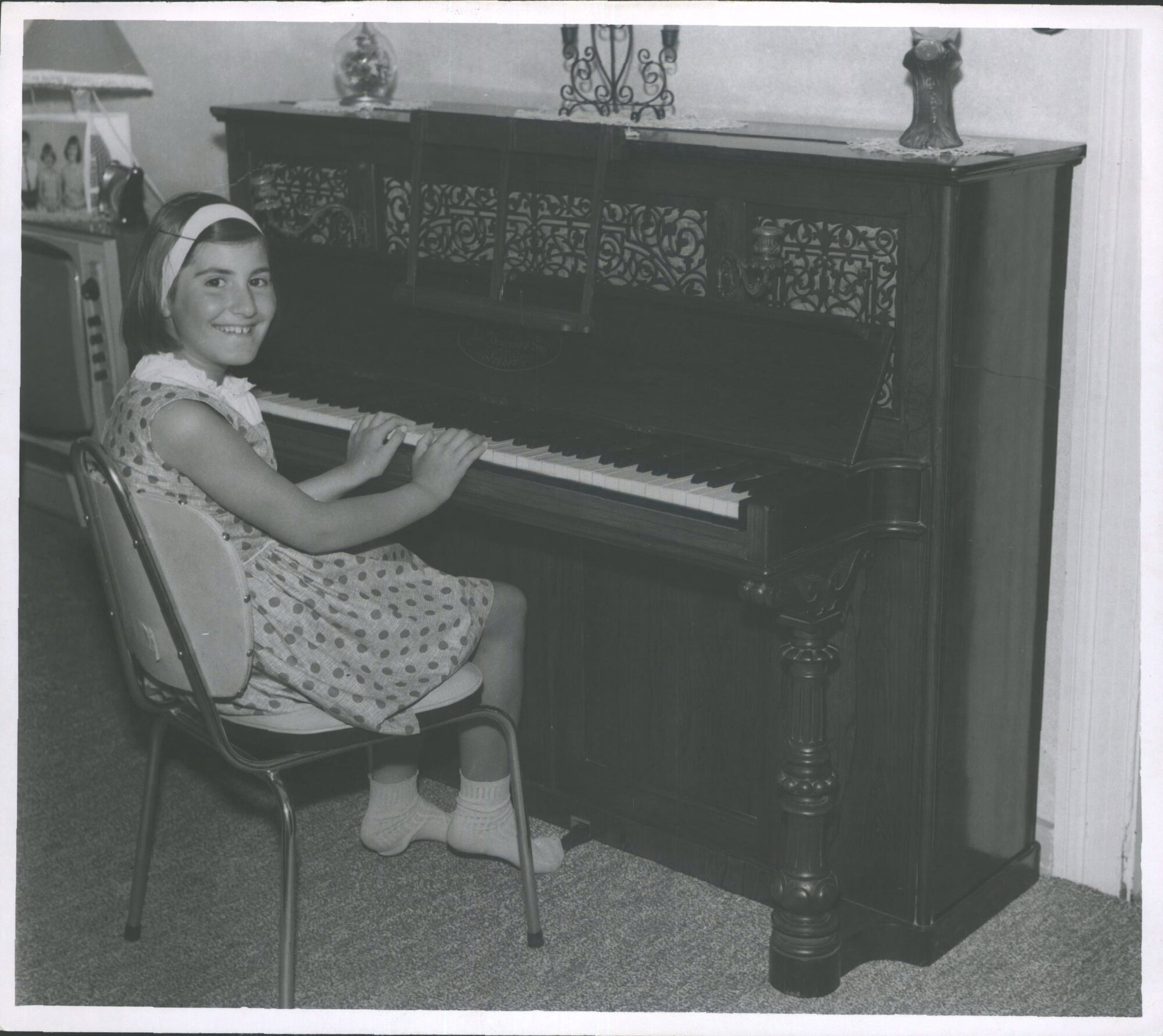 MARIA CHRISTAFSKI, aged 8, at the 100-year old piano in its new home  at Courtney St, Motueka