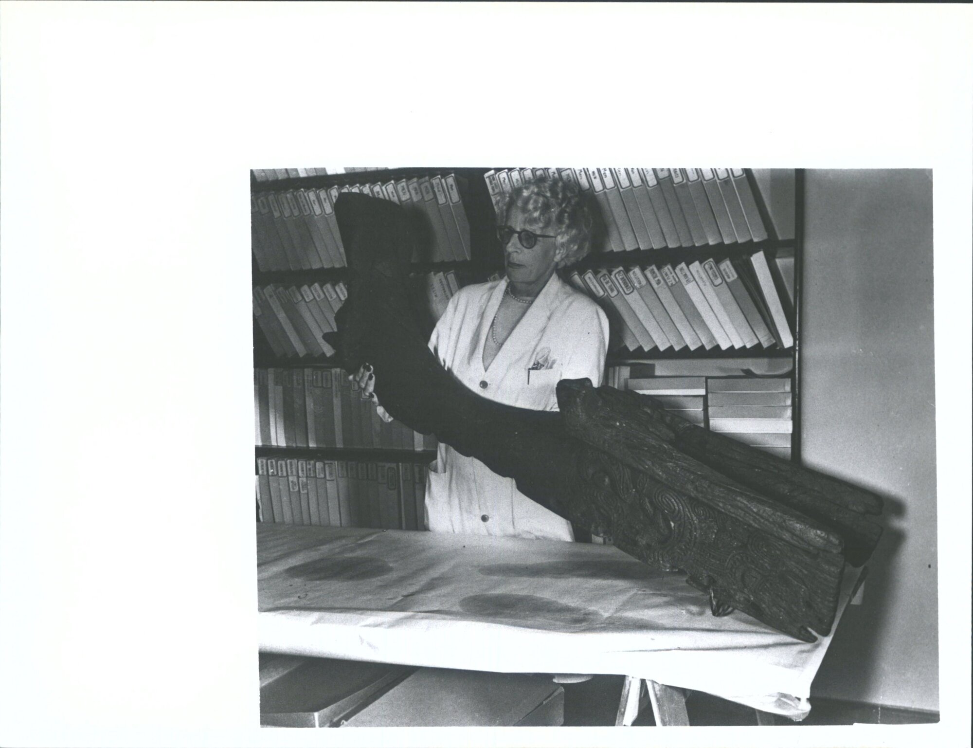 Miss M. Molineux, of the staff of the Dominion Museum, Wgtn, with an ancient Maori Canoe Prow found recently in a plantation at