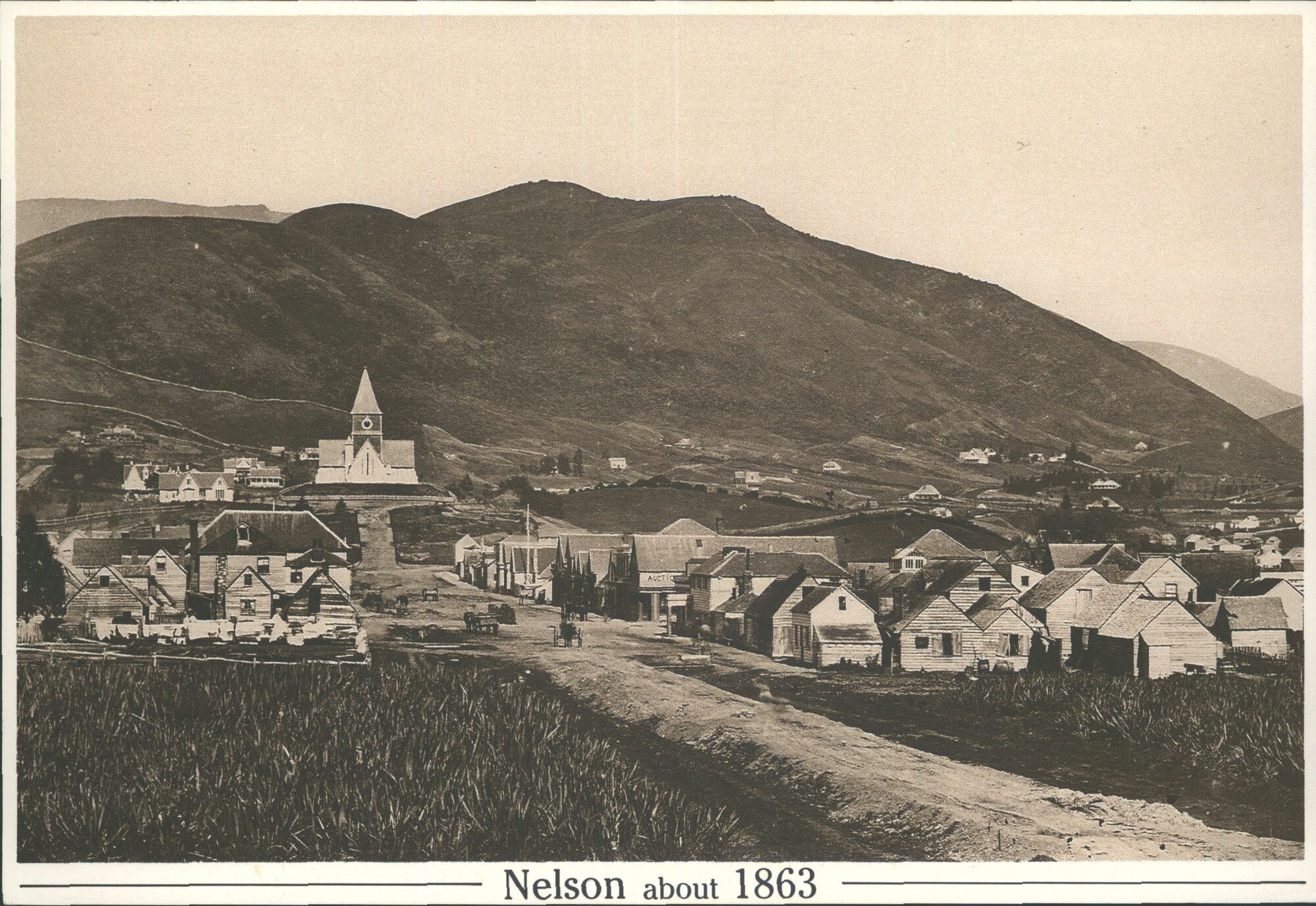 Trafalgar St, Nelson NZ, about 1863, looking south to the intersection with Bridge St. The original cathedral stands on Church H