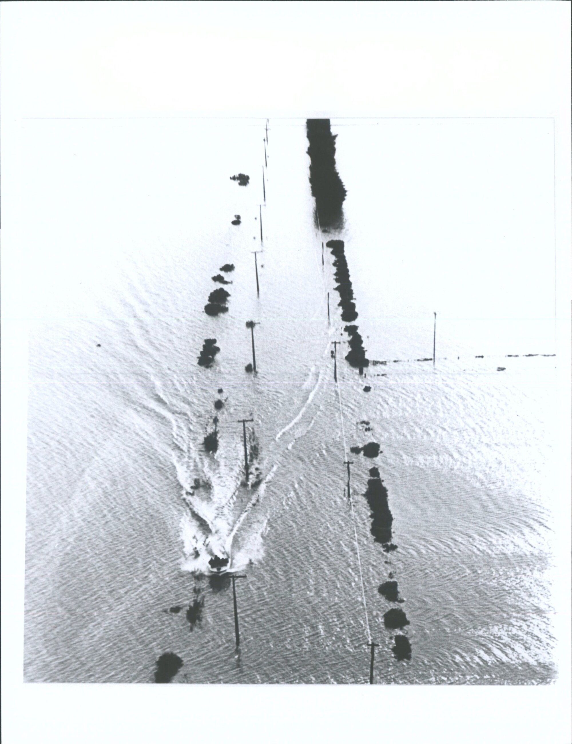 Aerial photograph of jetboat moving along flooded roads