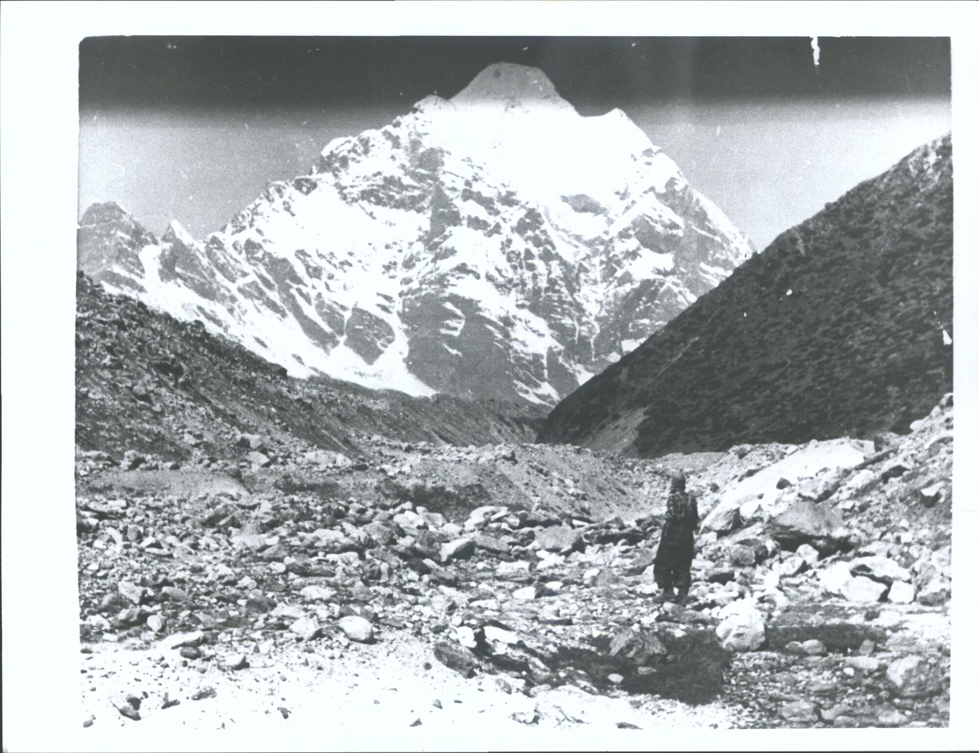Sir Edmund Hillary Studies the mighty Himalayan Peaks from the rock strewn Barum Valley after reaching base camp at a height of