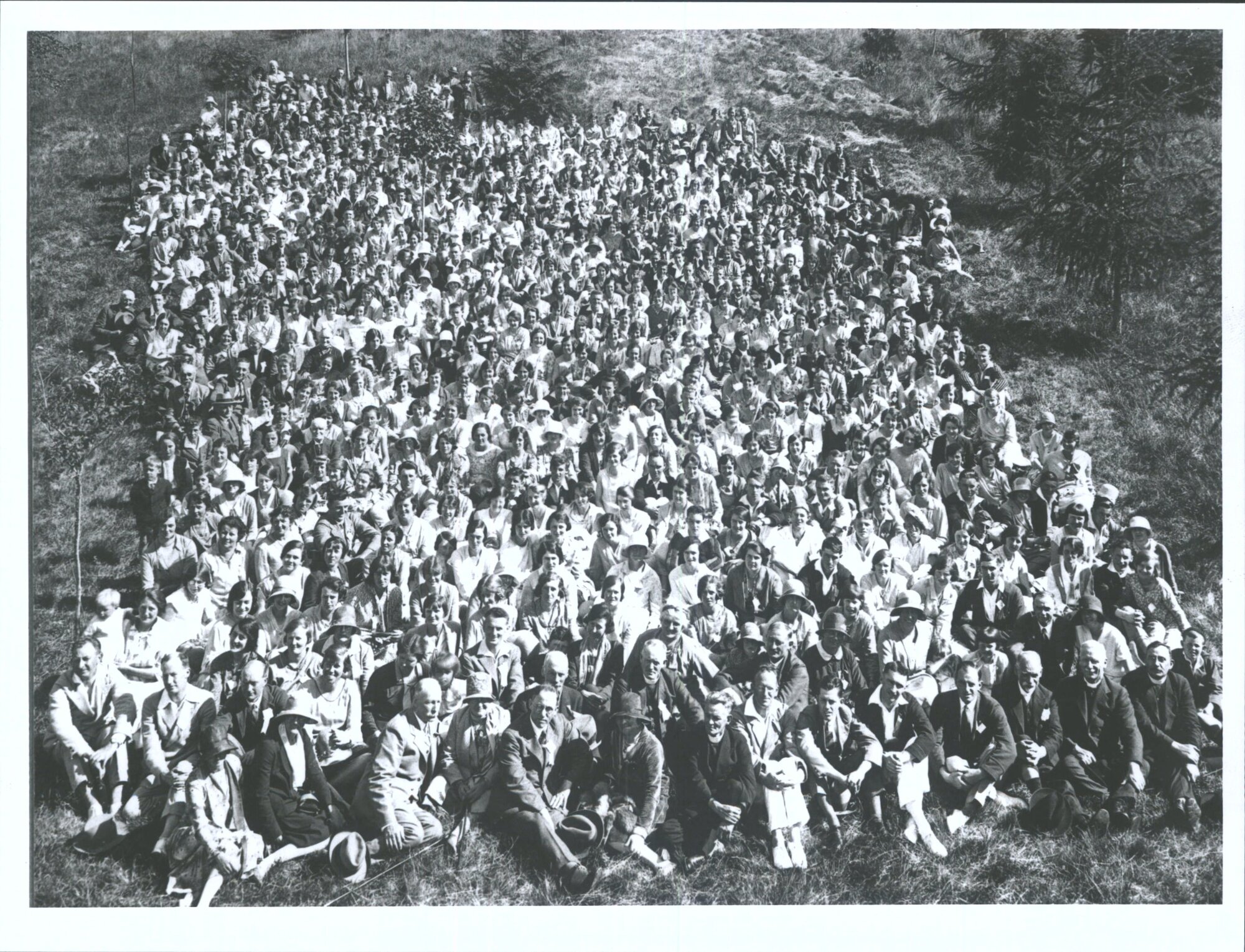 A large group of people sitting in the grass