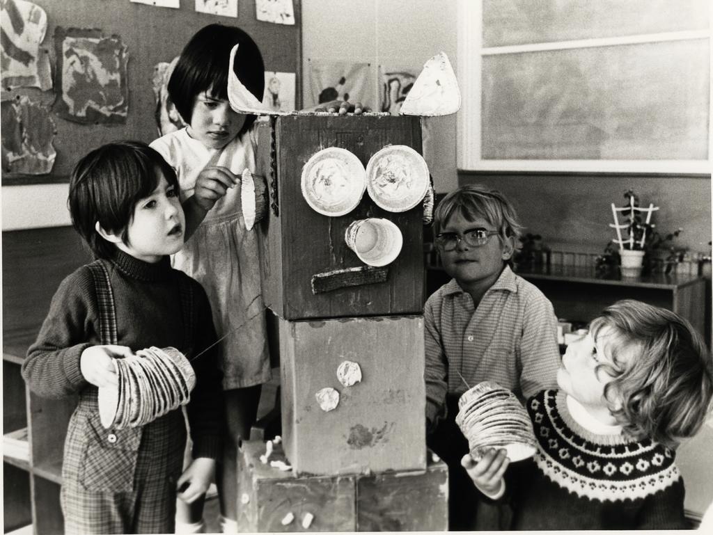 Four children with a robot made from boxes and other materials