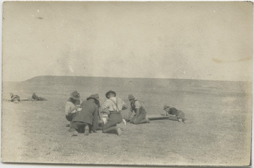 Group of men kneeling and lying on the ground