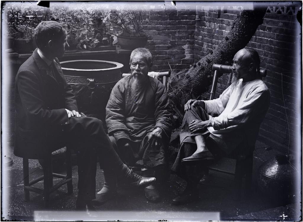Rev. Mawson [?] and two Chinese men in back courtyard