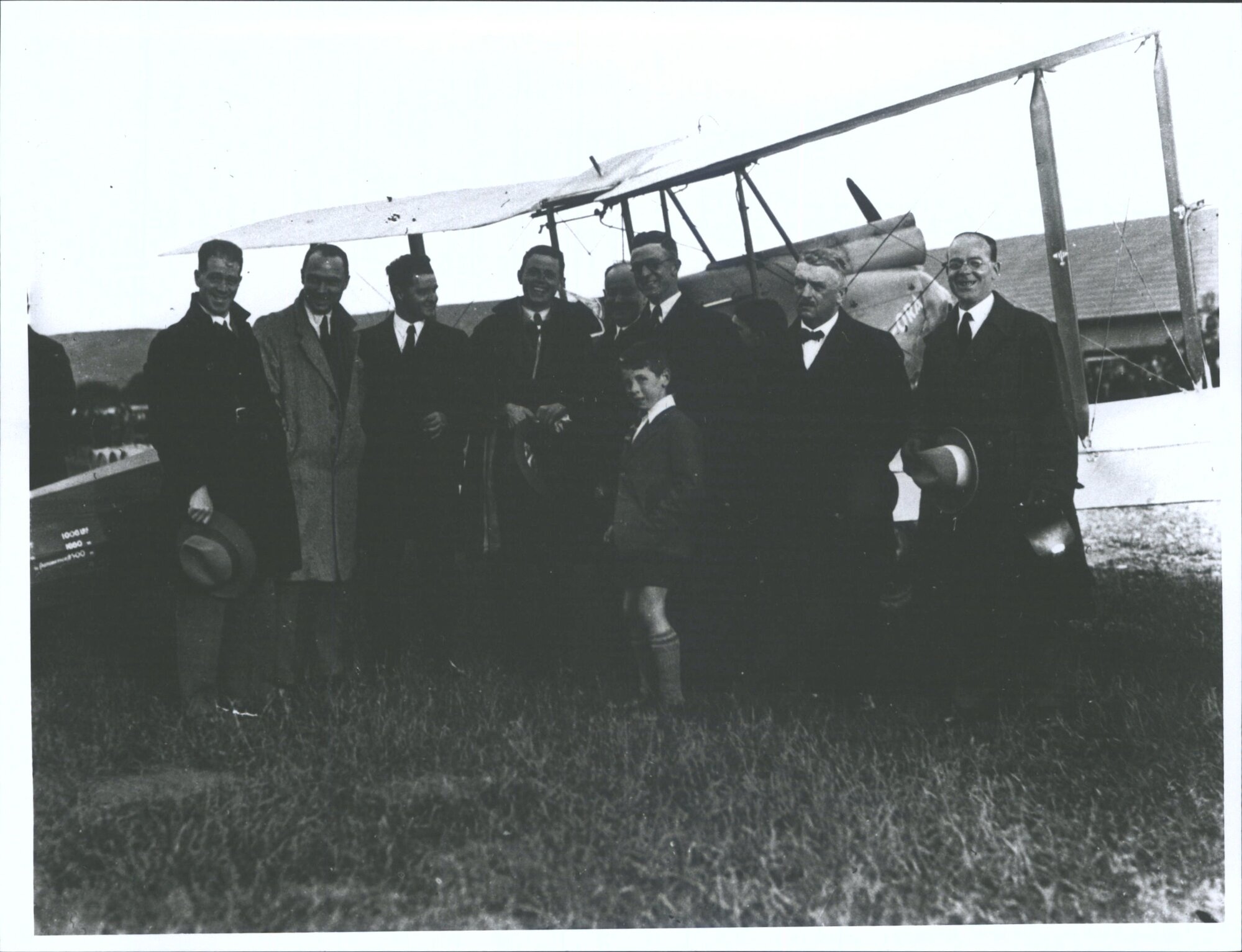 [Group of men and boy in front of plane]