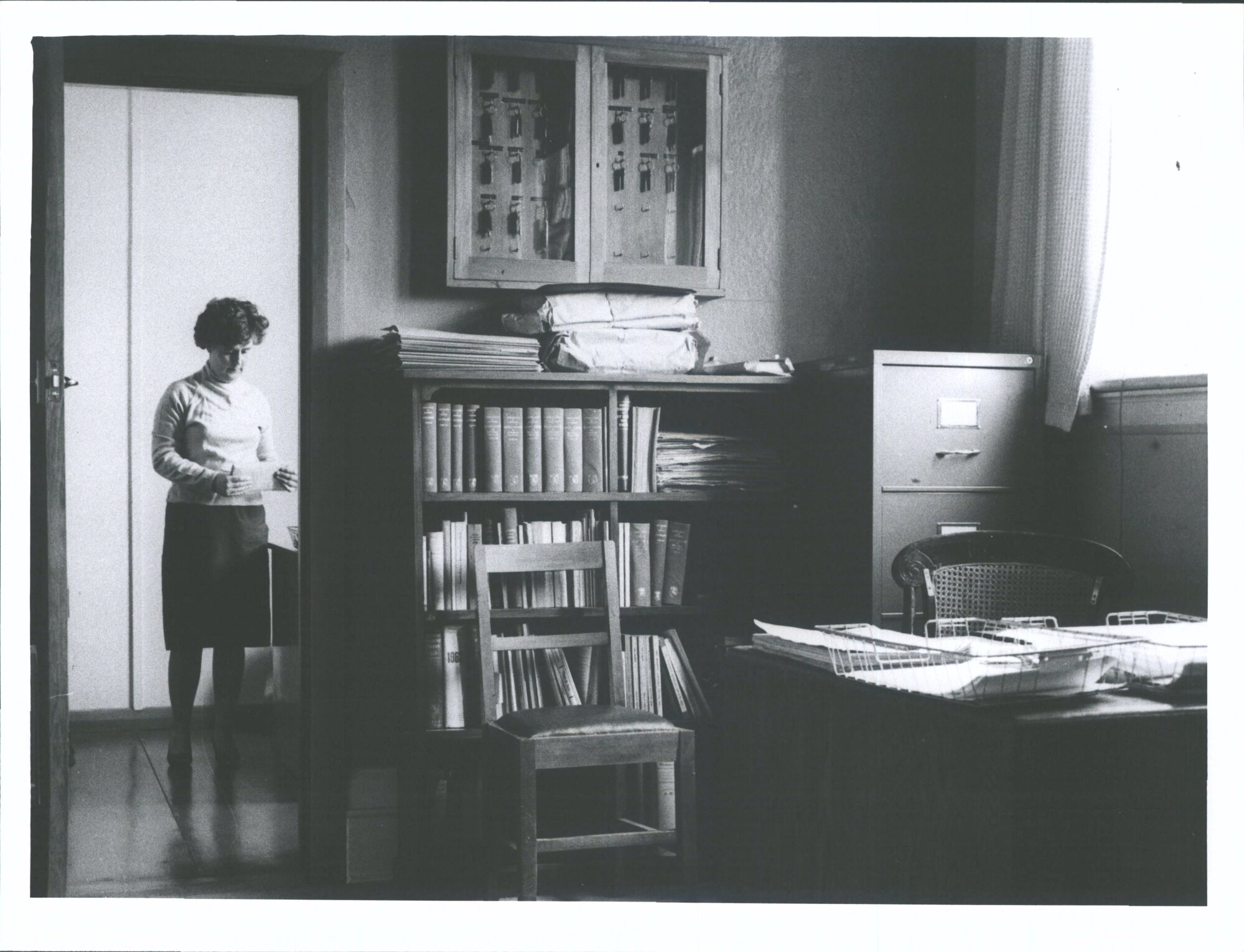 Miss E. J. Robinson in Deputy Librarian's  room. Librarian's room in foreground