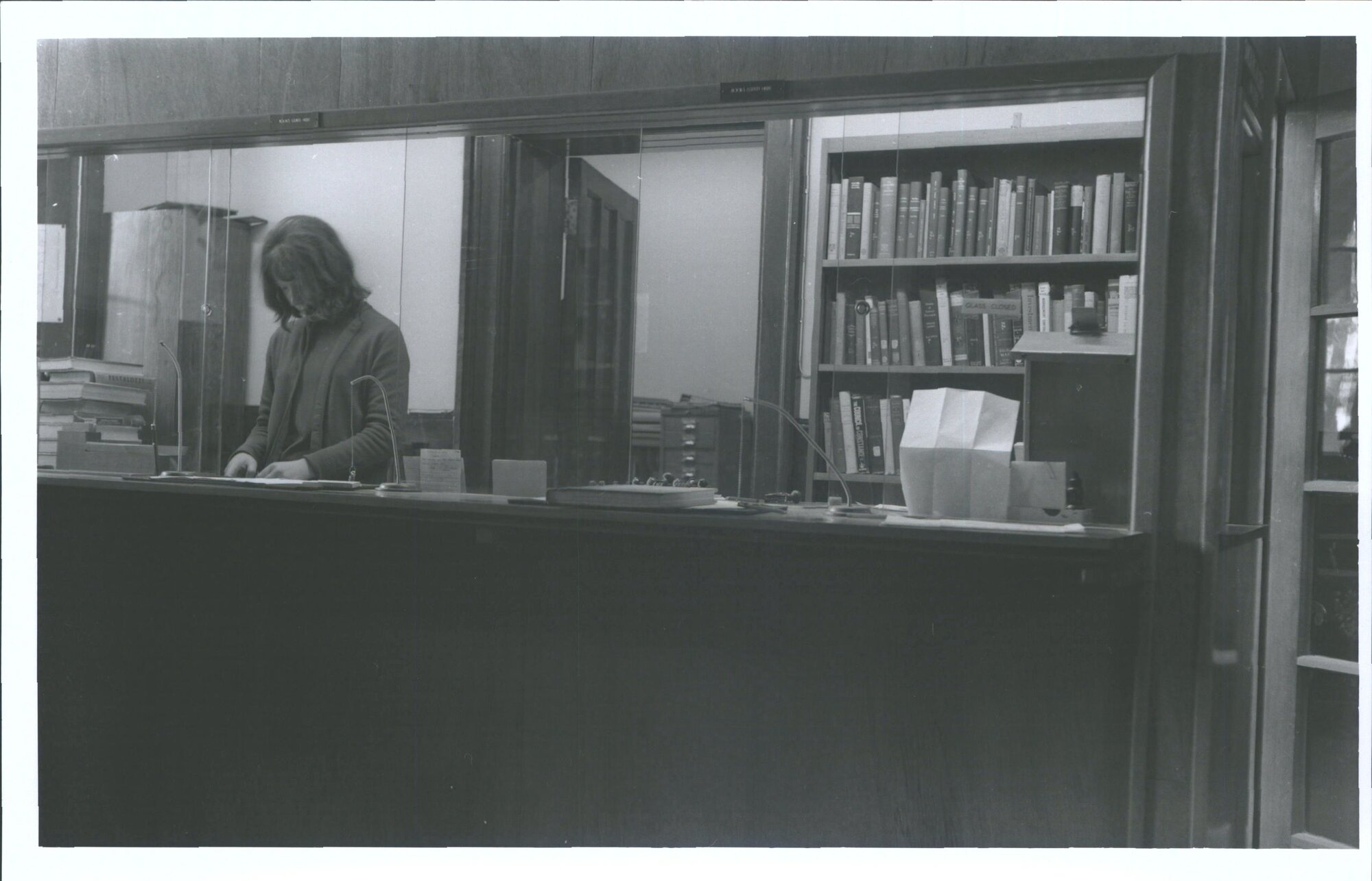 Miss P. J. Sutherland at Circulation desk in main foyer, Showing Reserve book area at back