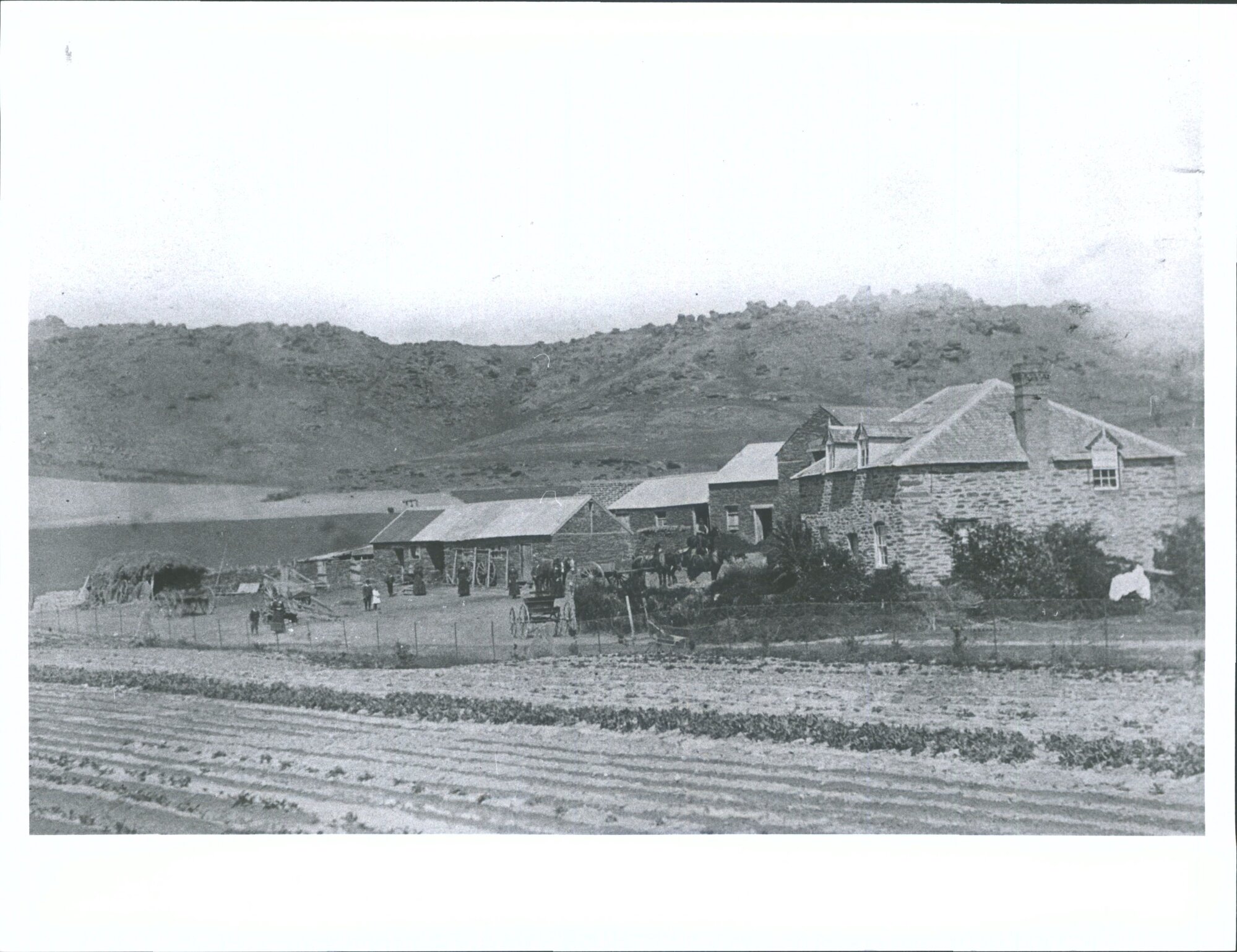 Mr &amp; Mrs Butler and family outside their home and farm buildings