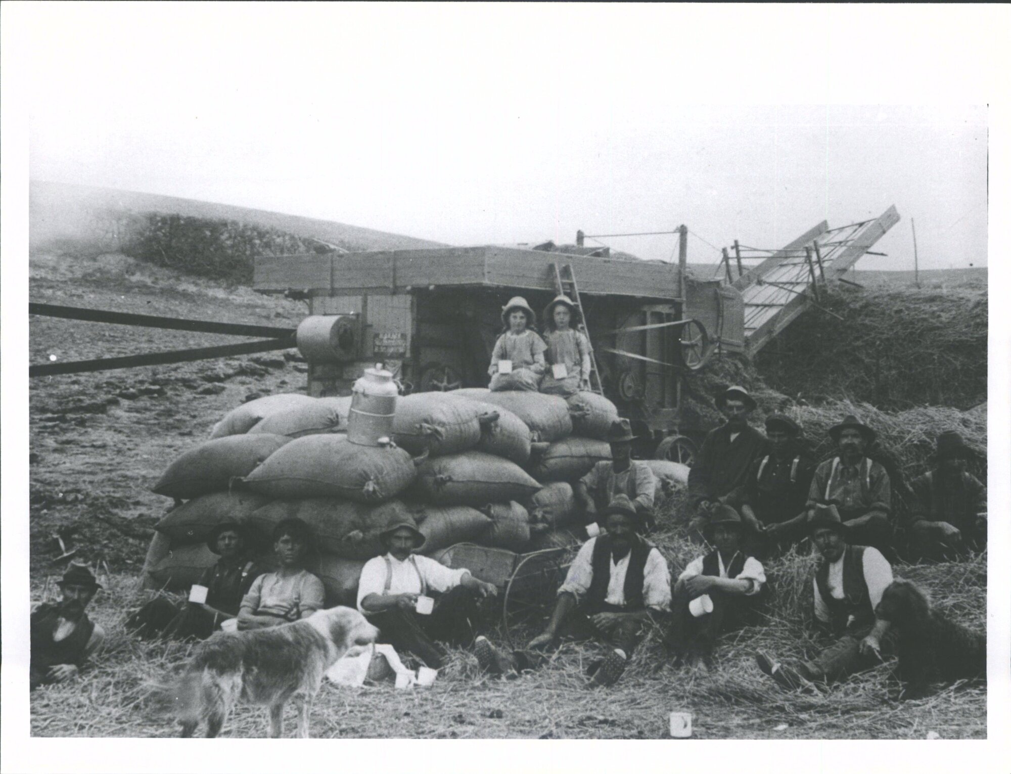 Sacks of wheat &amp; threshing Mill.