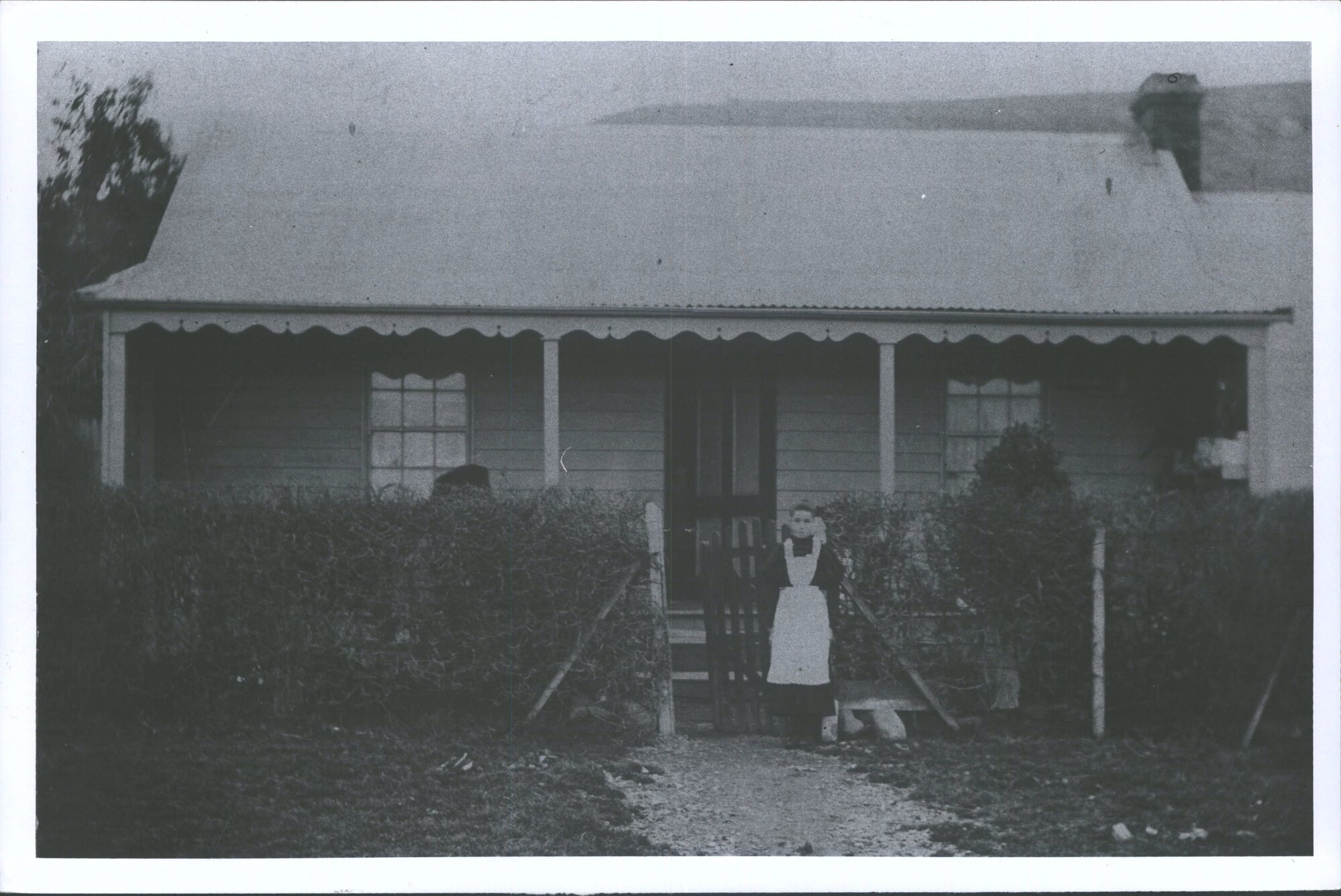 Unidentified Woman Standing in front of Home of Robert Finnie, Butcher, East Taieri