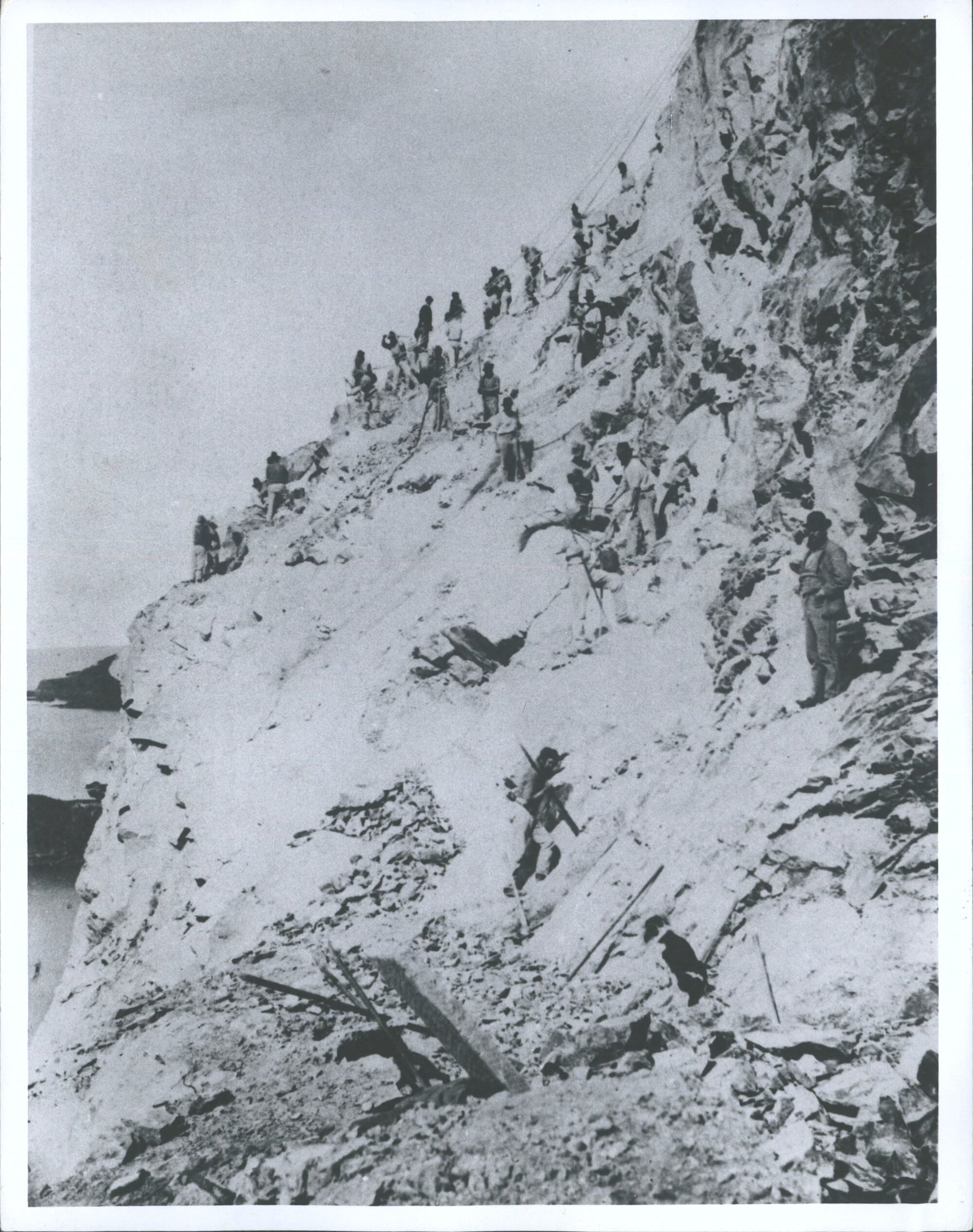 PURAKANUI Workman some secured by ropes use crowbars &amp; hammers to cut railway track on a cliff face near Purakanui Otago 1875