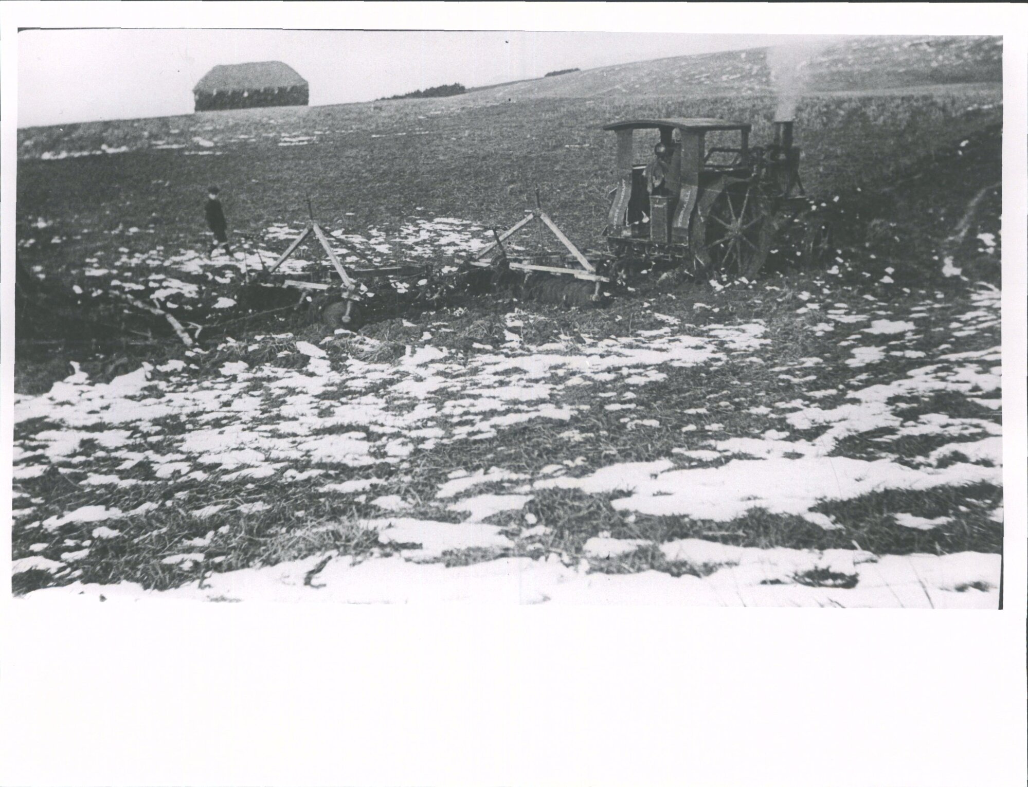 "Two gangs of discs followed by harrows, under eye of watchful boy."