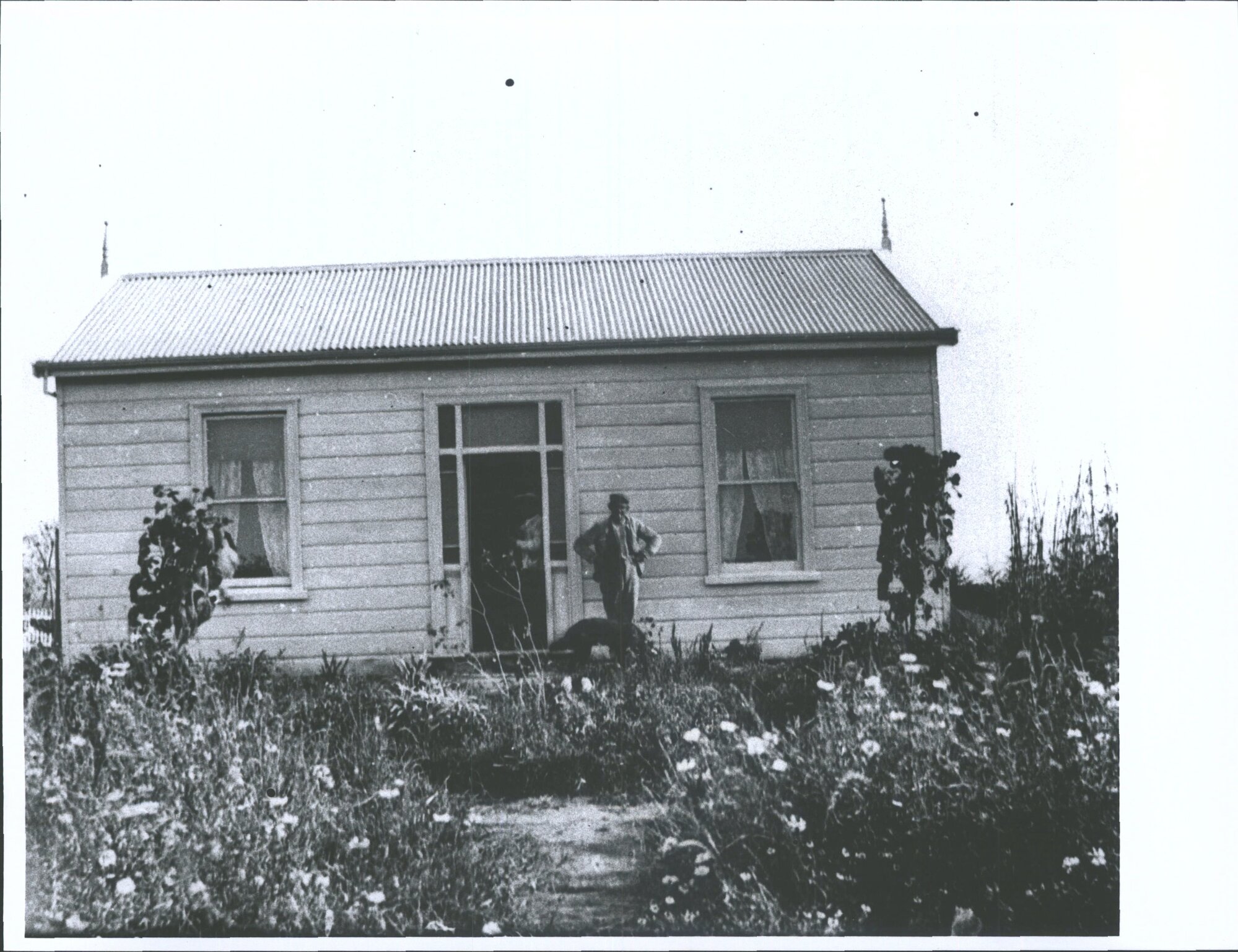 Unidentified couple and dog outside house