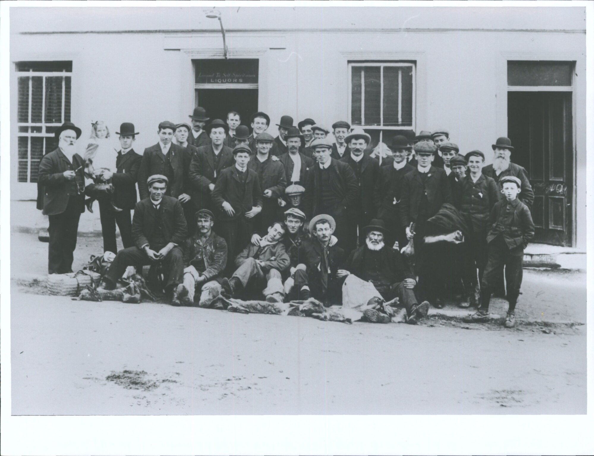 Large group of gentlemen posing outside a liquor retailer