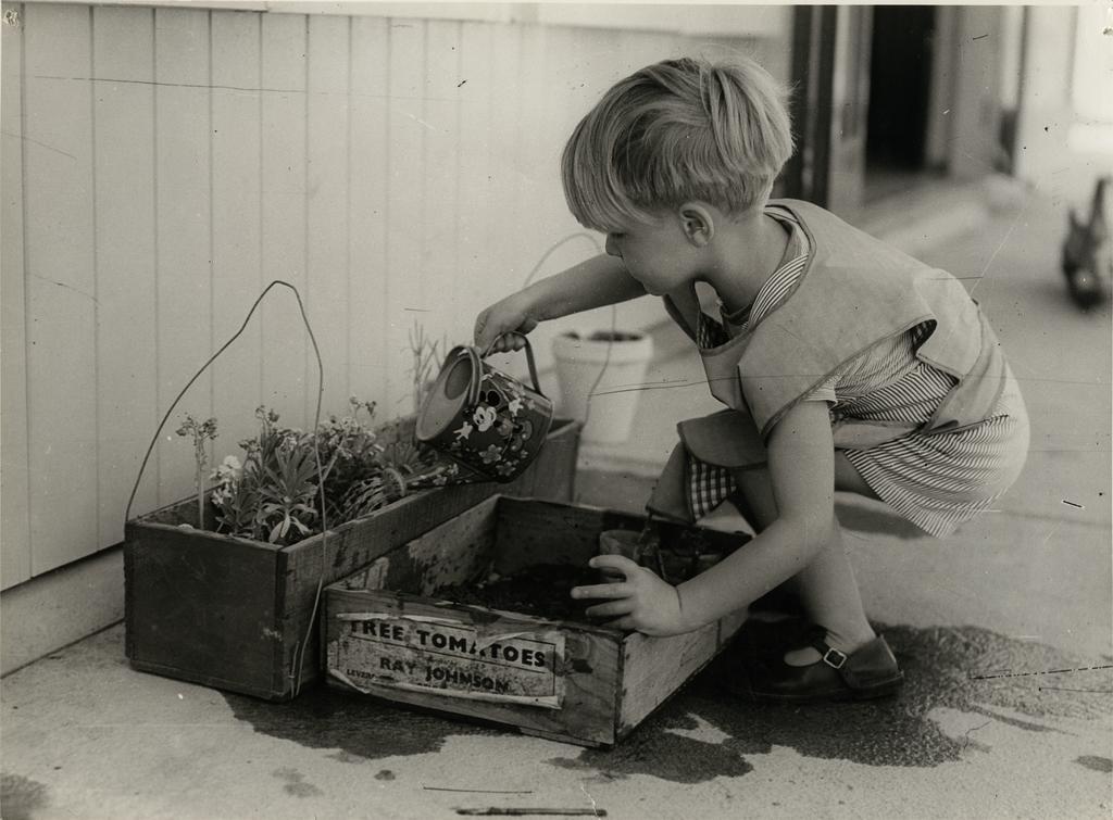'Child playing with watering can'