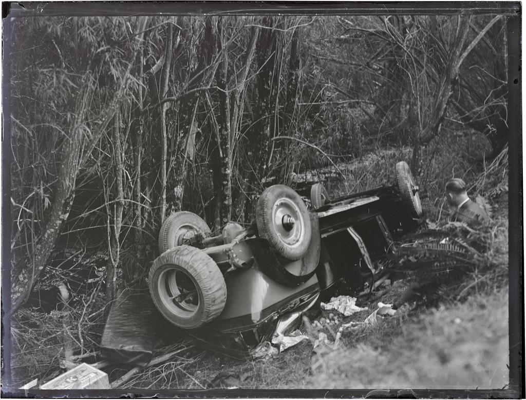 Wrecked motor car at accident site, next to trees and a waterway