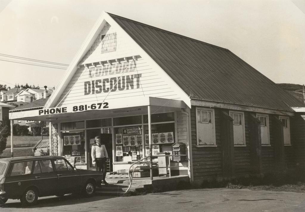 Shopkeeper Bill Waugh in front of Concord Discount Store