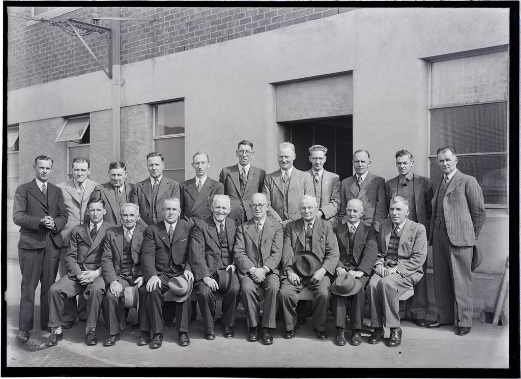 Group of male staff in front of packaging department building, Coulls Somerville Wilkie, St Andrew Street, Dunedin