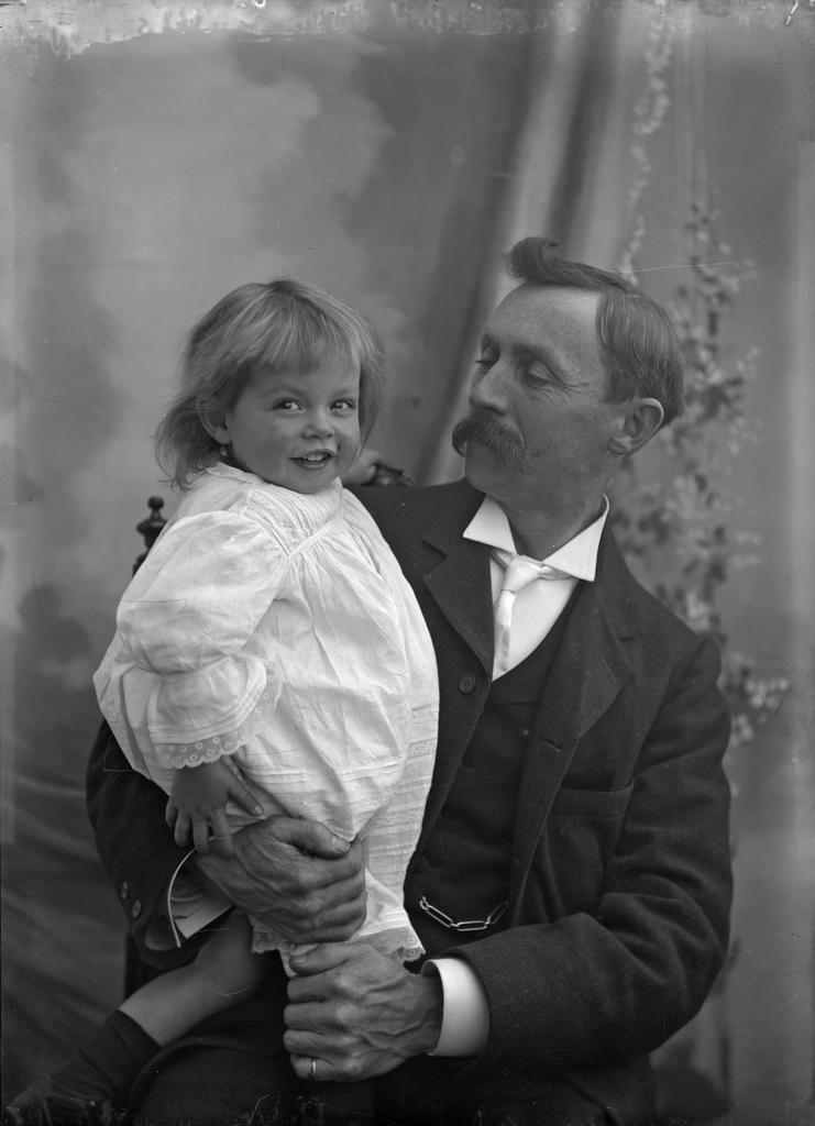 Fred McGeorge in dress, held by Ethel McGeorge