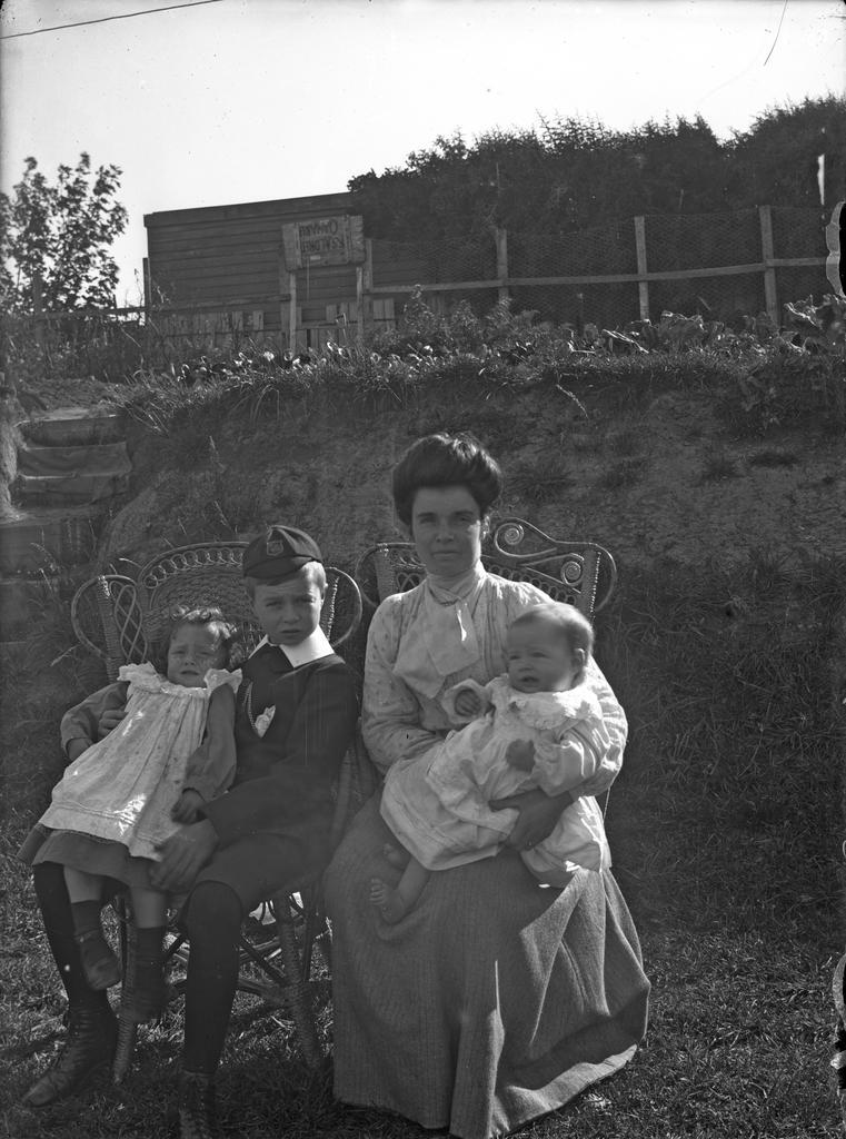 'Behind school house at Oamaru, Ve, Bert, Ethel and baby'