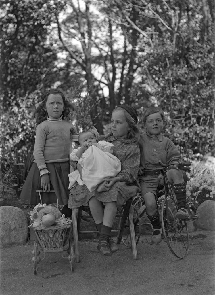 McGeorge children, Ve holding doll's pram, Em holding Alison, Fred on bike