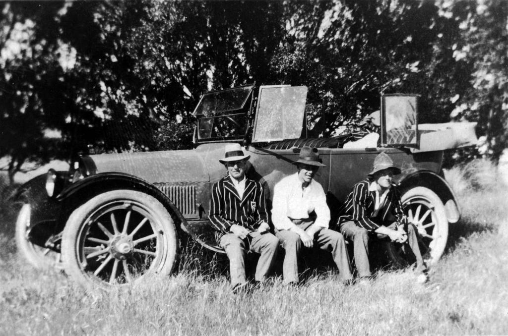 Men sitting by car