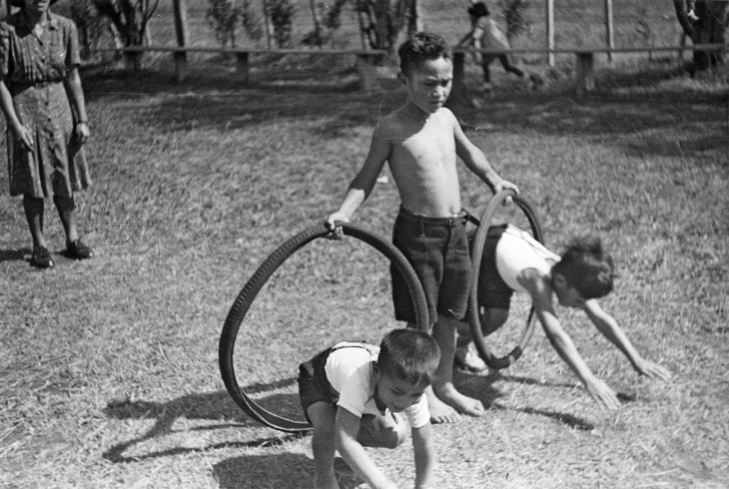 Boys diving through 'hoops' of bicycle tyres