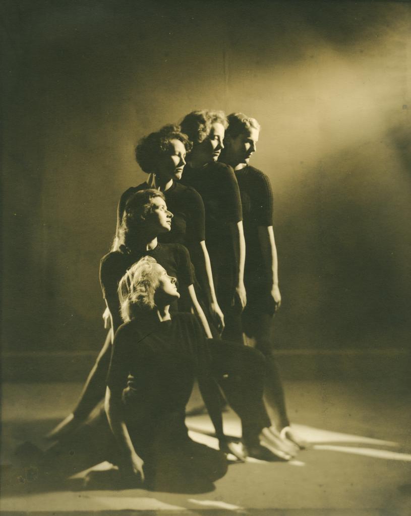 Five women in dance pose, arms lowered
