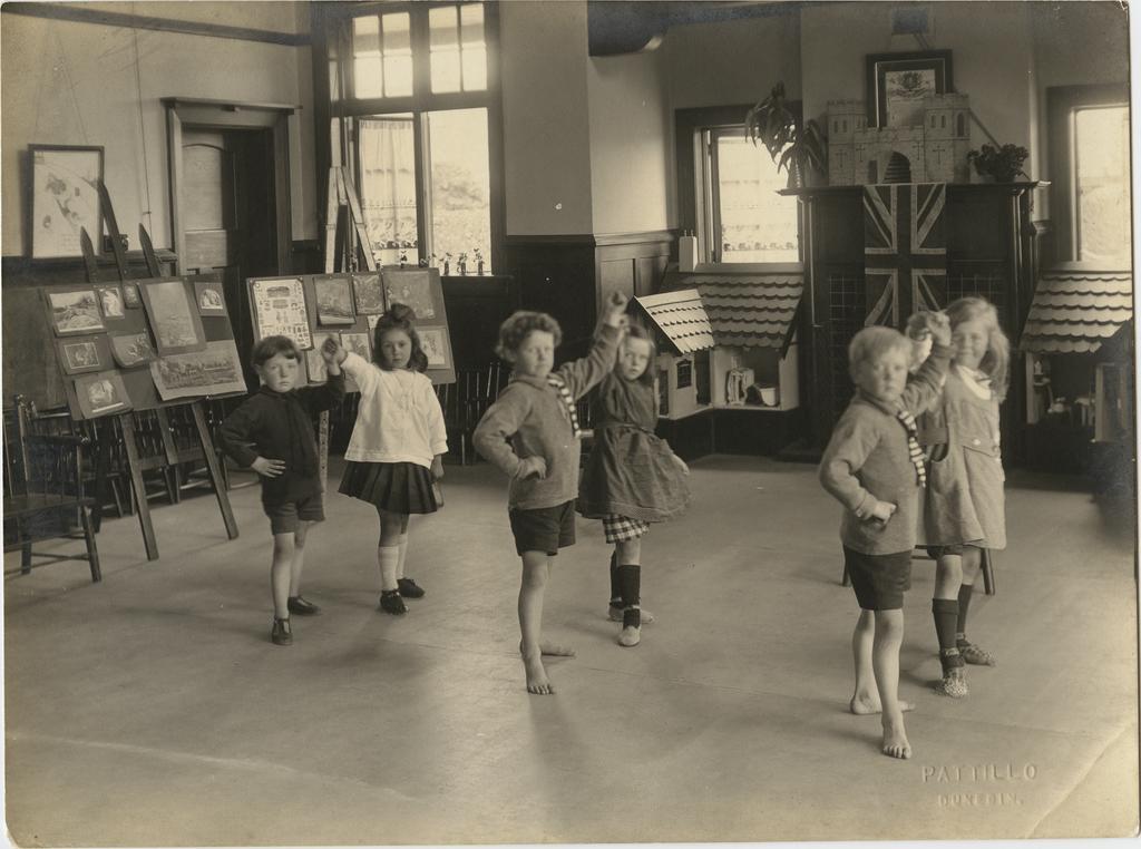Children in dance poses inside kindergarten