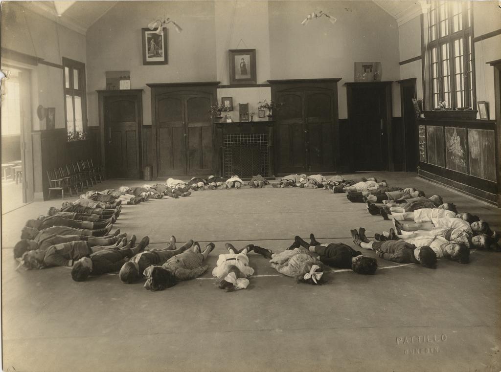 Children lying in circular formation on kindergarten floor