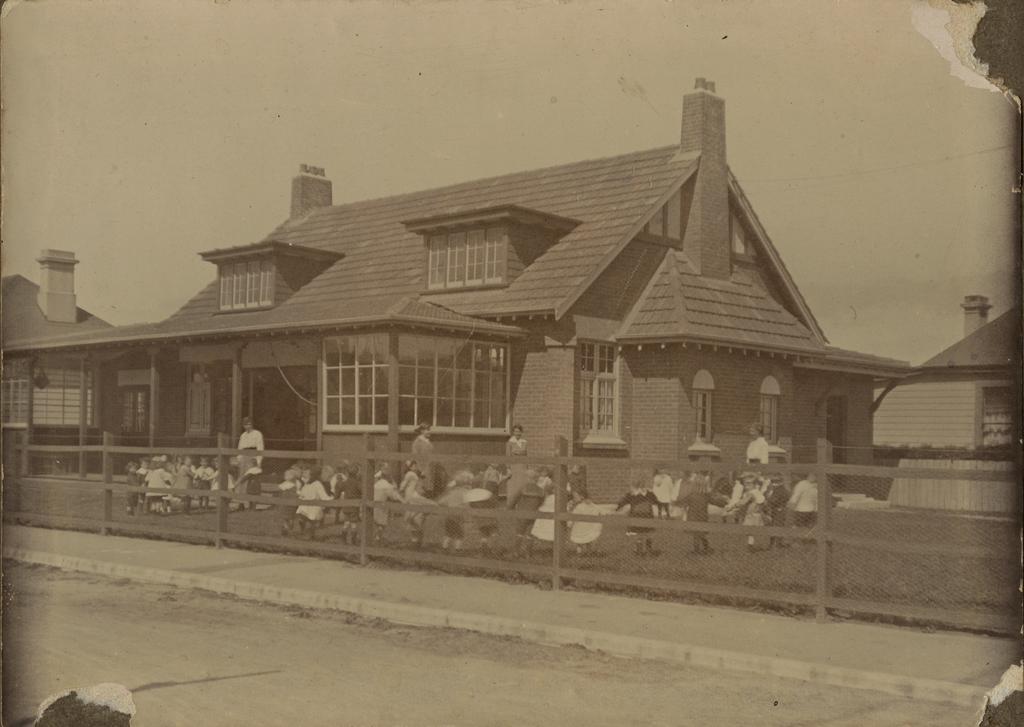 Kindergarten building with children and women outside