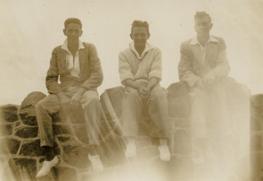 Three young men on wall