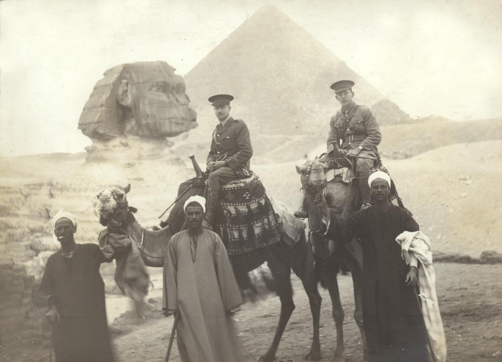 Thomas Christian and another officer on camels with Sphinx and Pyramid in background
