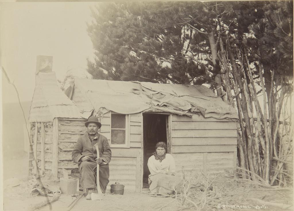 Jack Mamaru and unidentified wahine Māori in front of dwelling
