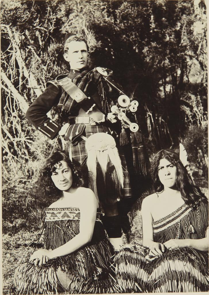 Pani Rehu, unidentified wāhine Māori, and unidentified man in Scottish dress and bagpipes