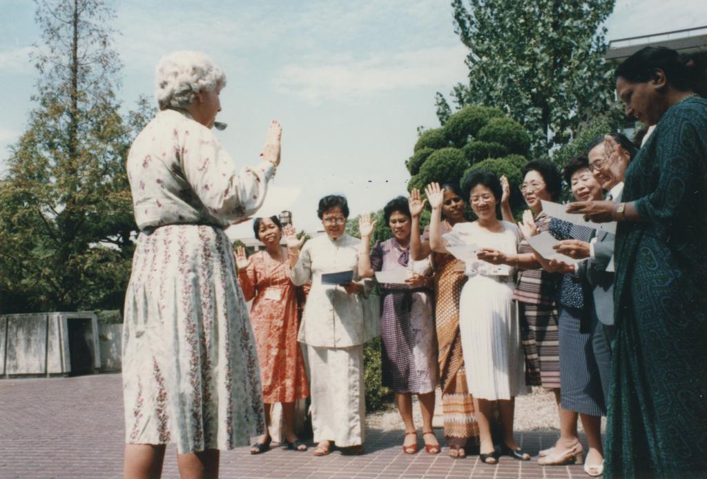 Professor Coleman in front of a group of people [taking a collective oath?]