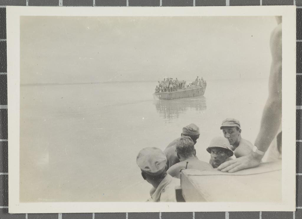Soldiers on landing craft departing island