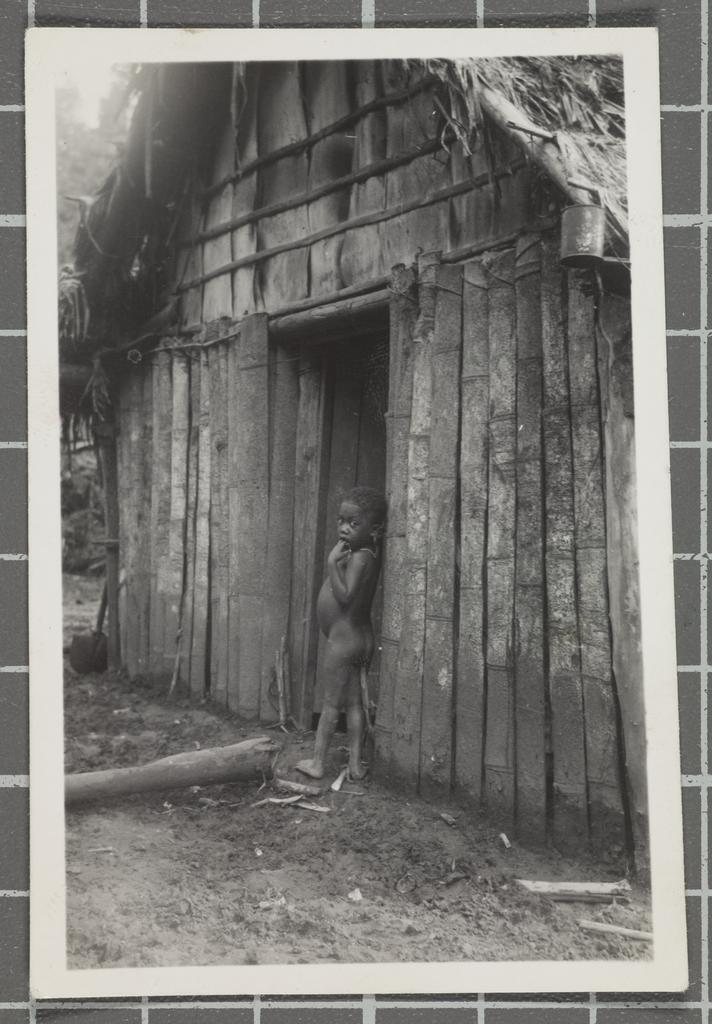Child outside a hut on the island of New Britain