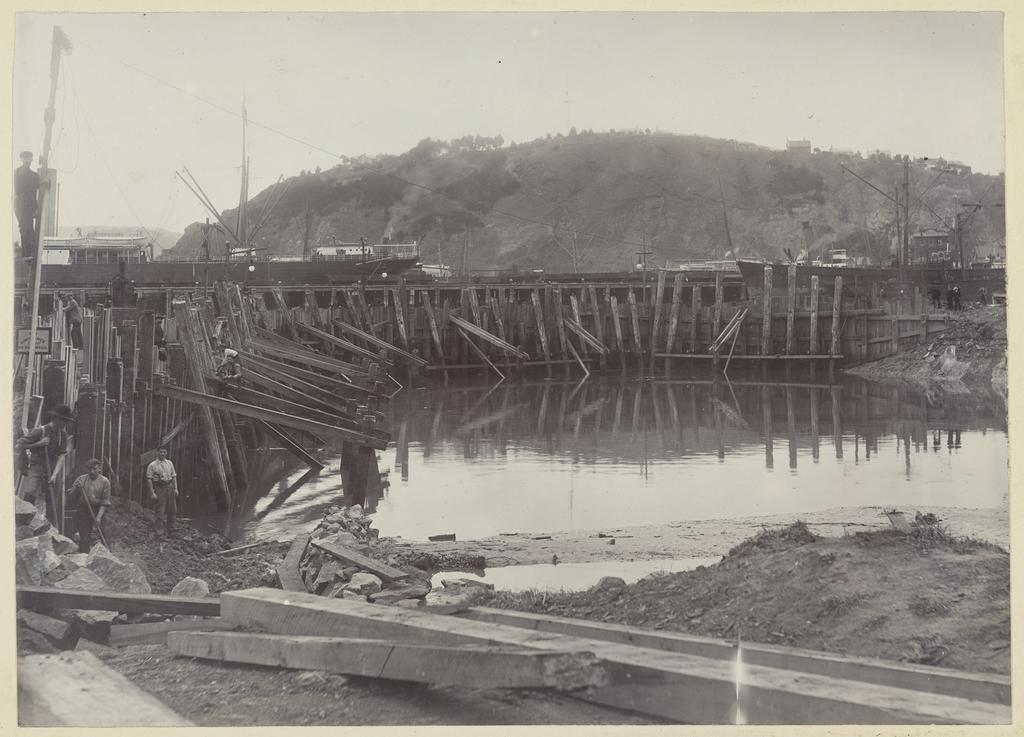 Group of men digging and placing beams