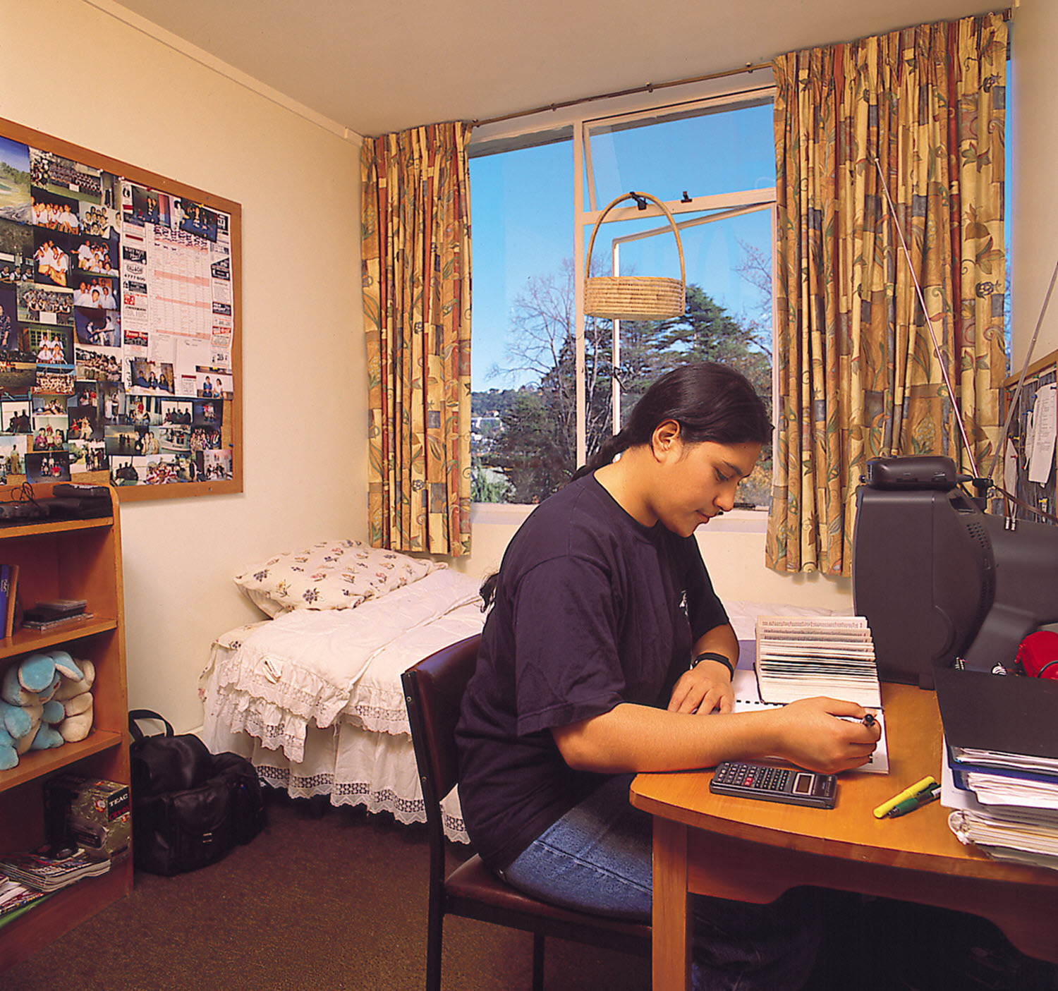 Studholme Hall resident seated at a desk in their room