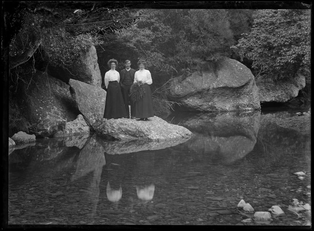 Three people beside the river