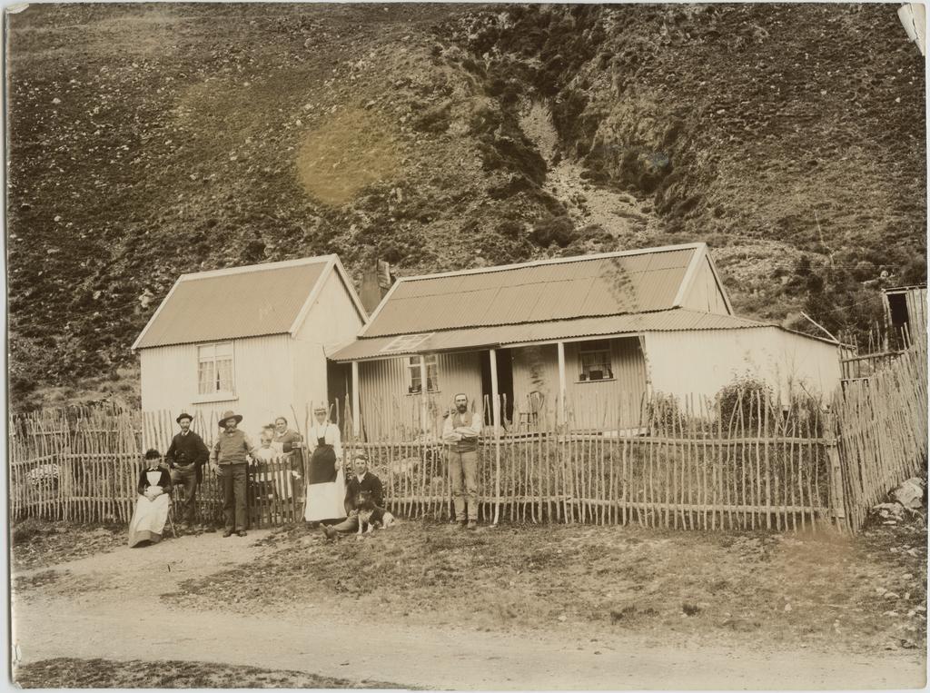 Family outside their corrugated iron homestead