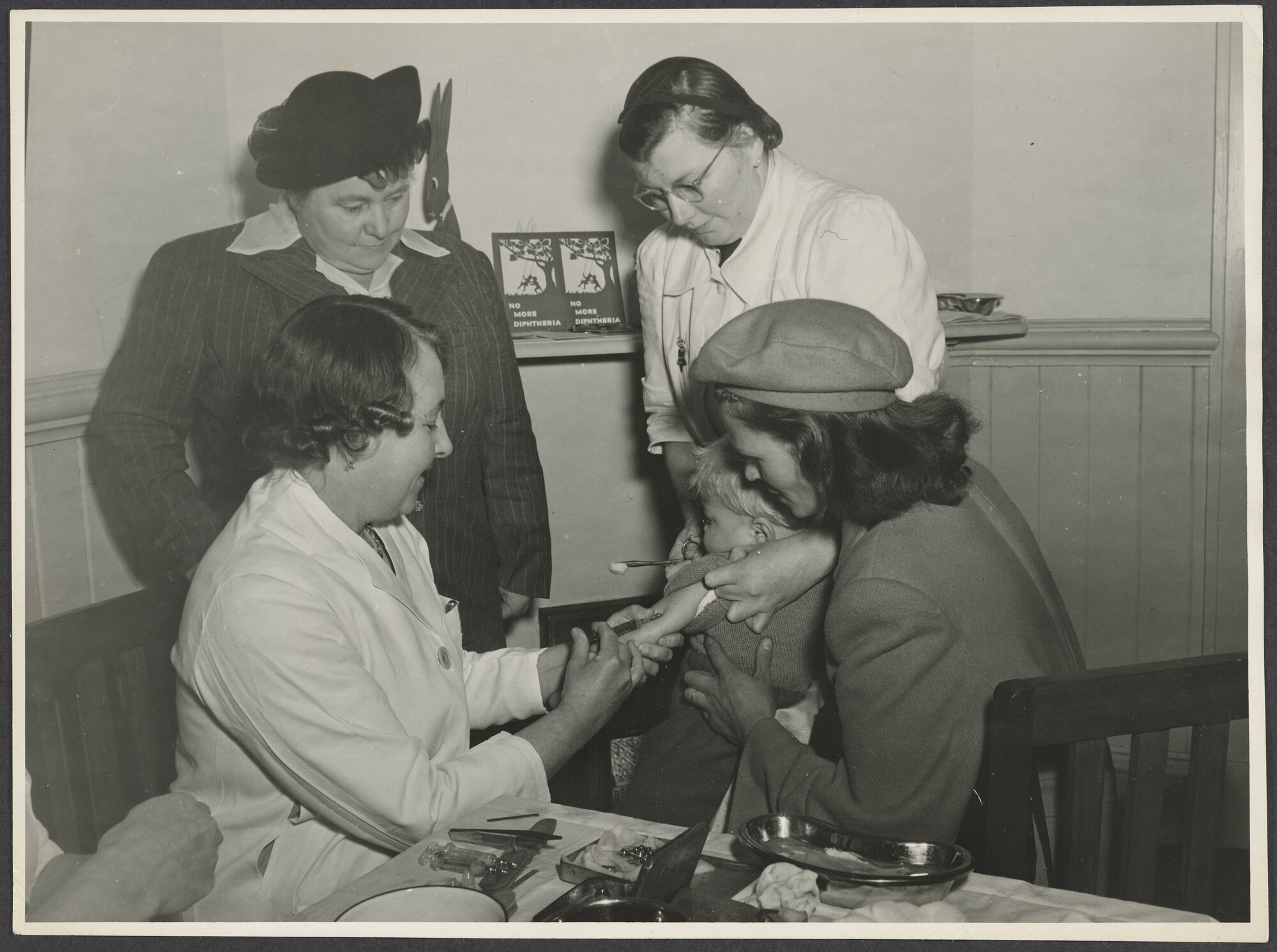 Mabel Howard with two medical staff, child, and caregiver [at a medical clinic]