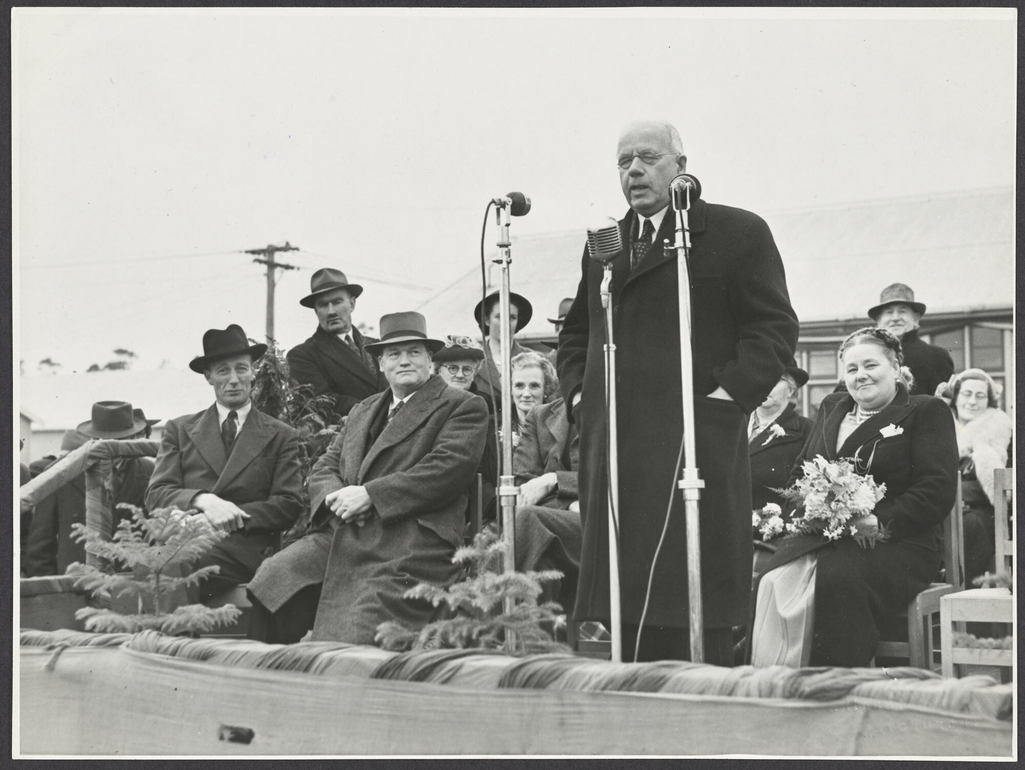 Peter Fraser speaking at the official opening of Howardville, with Mabel Howard seated behind him