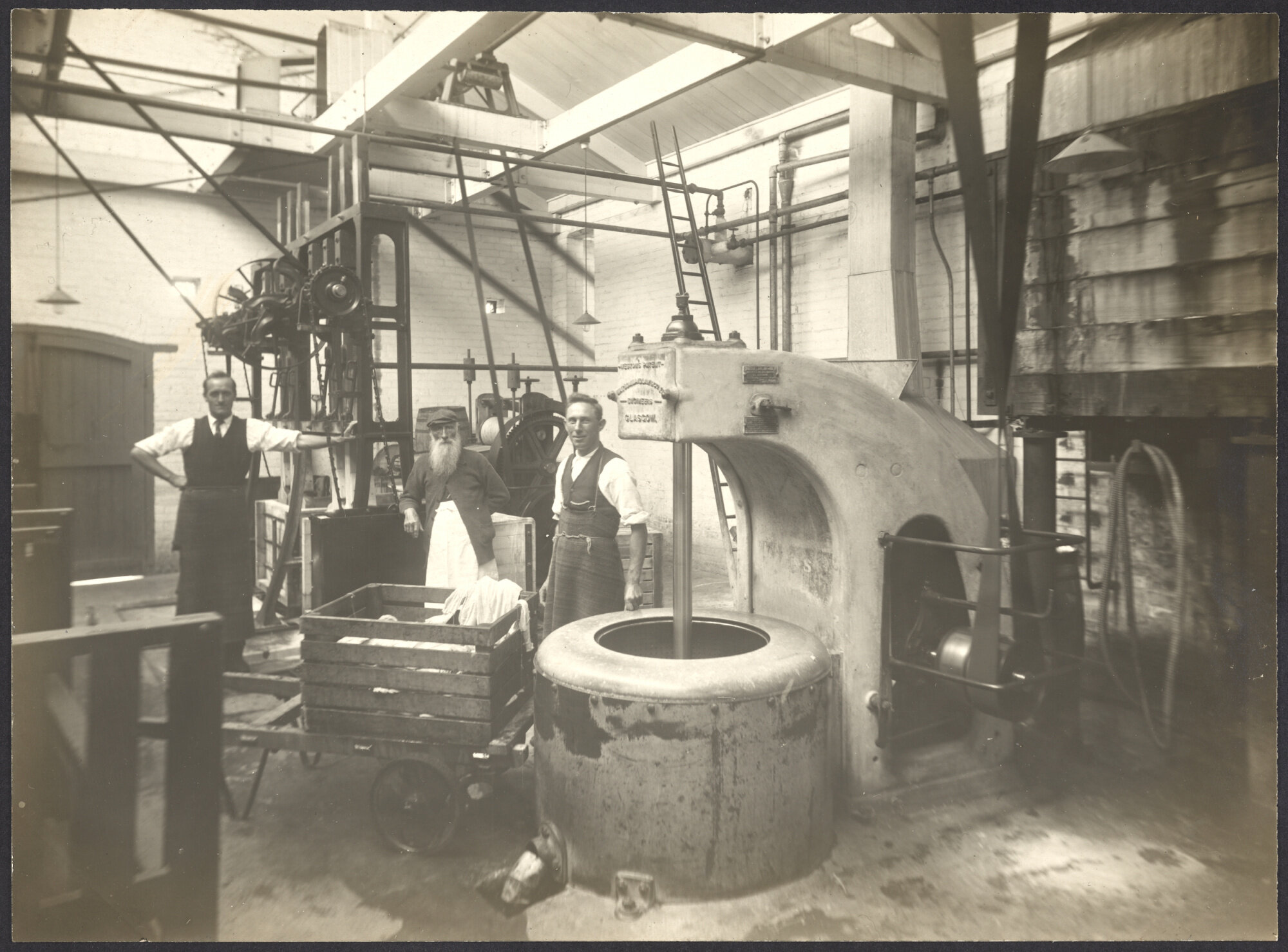 Workers with machine, possibly an industrial spin dryer