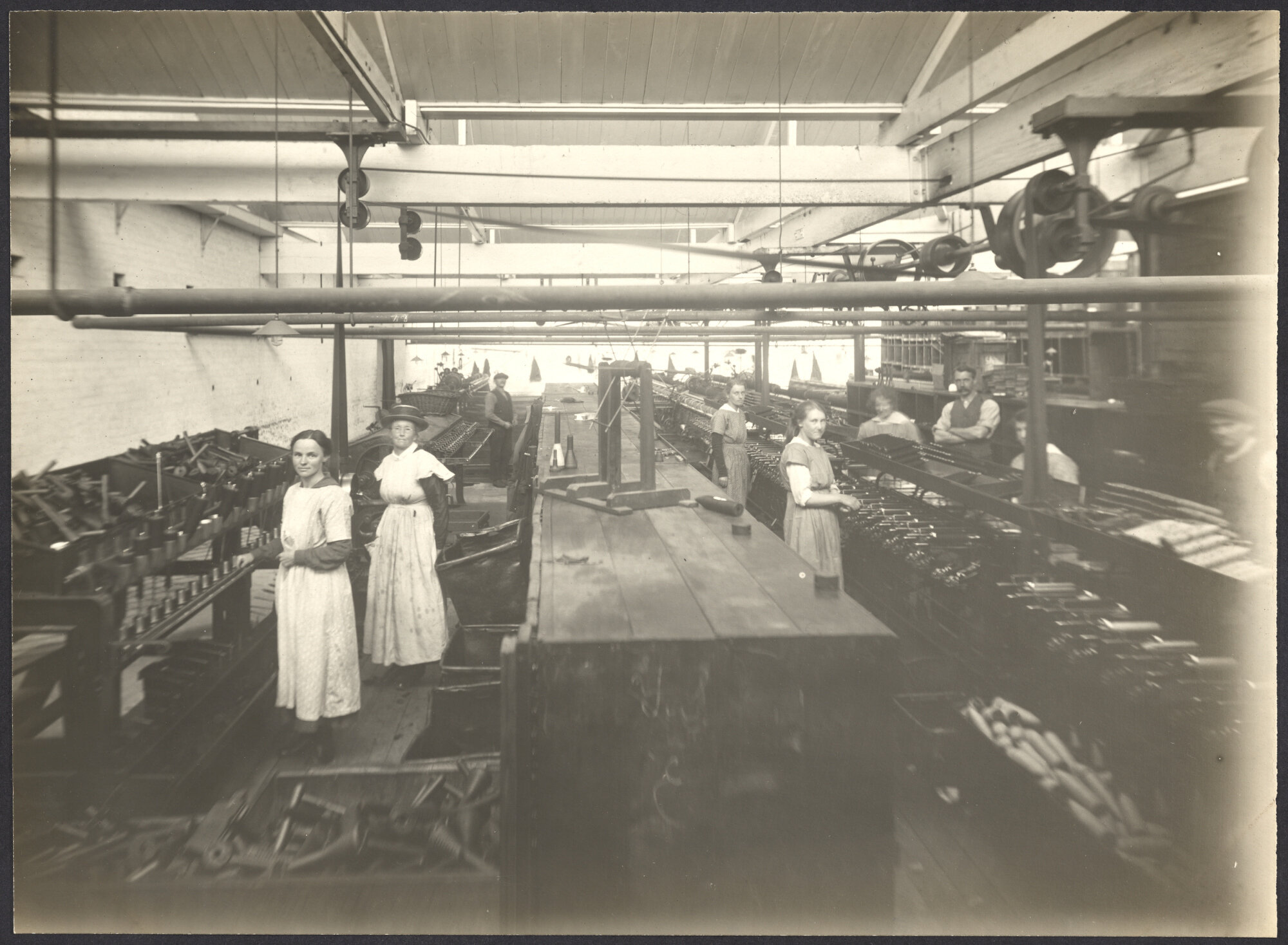 Workers, possibly winding yarn from spinning cones to weaving pirns or bobbins