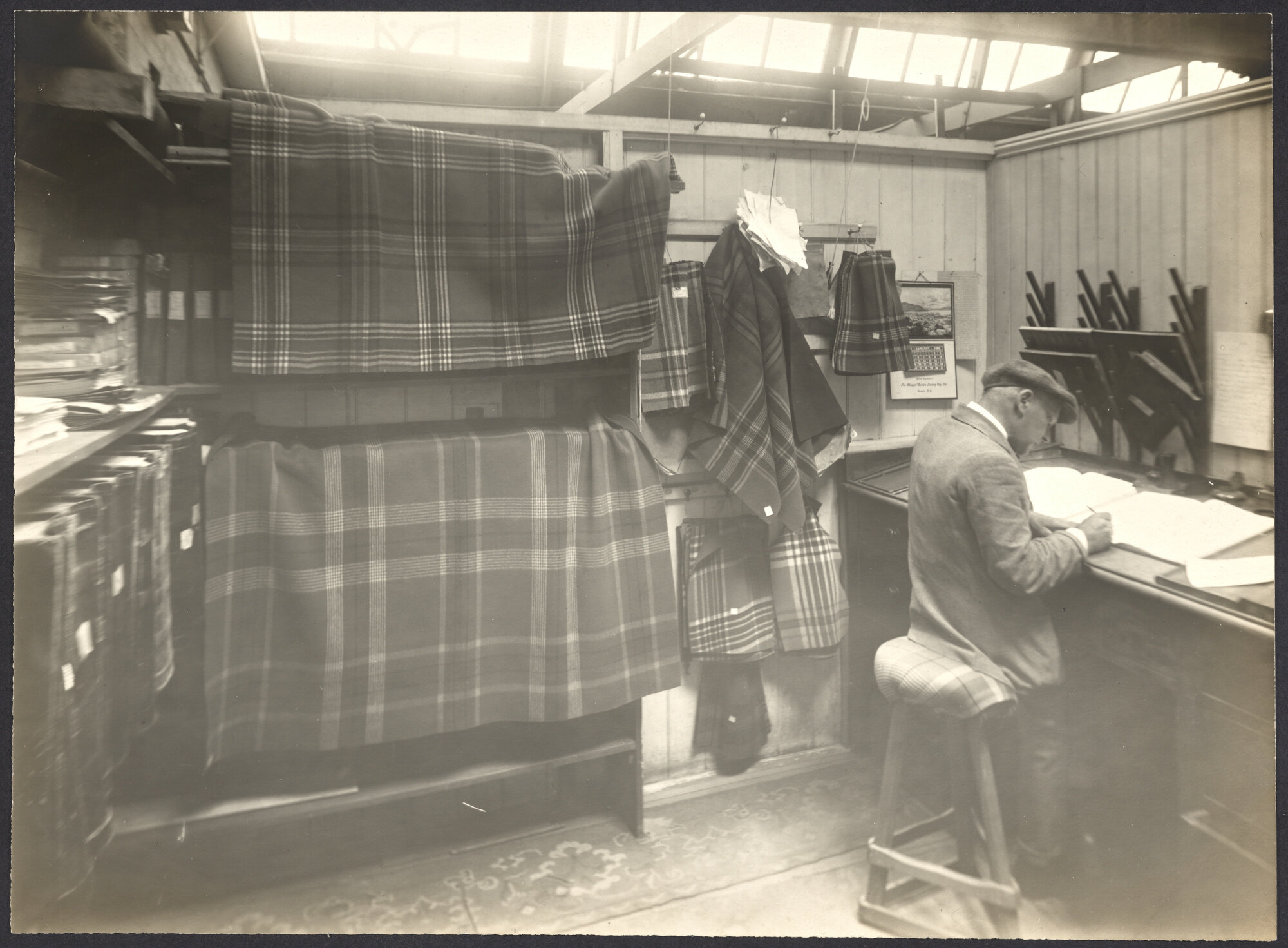 Man in office doing book work with display of blankets and fabric
